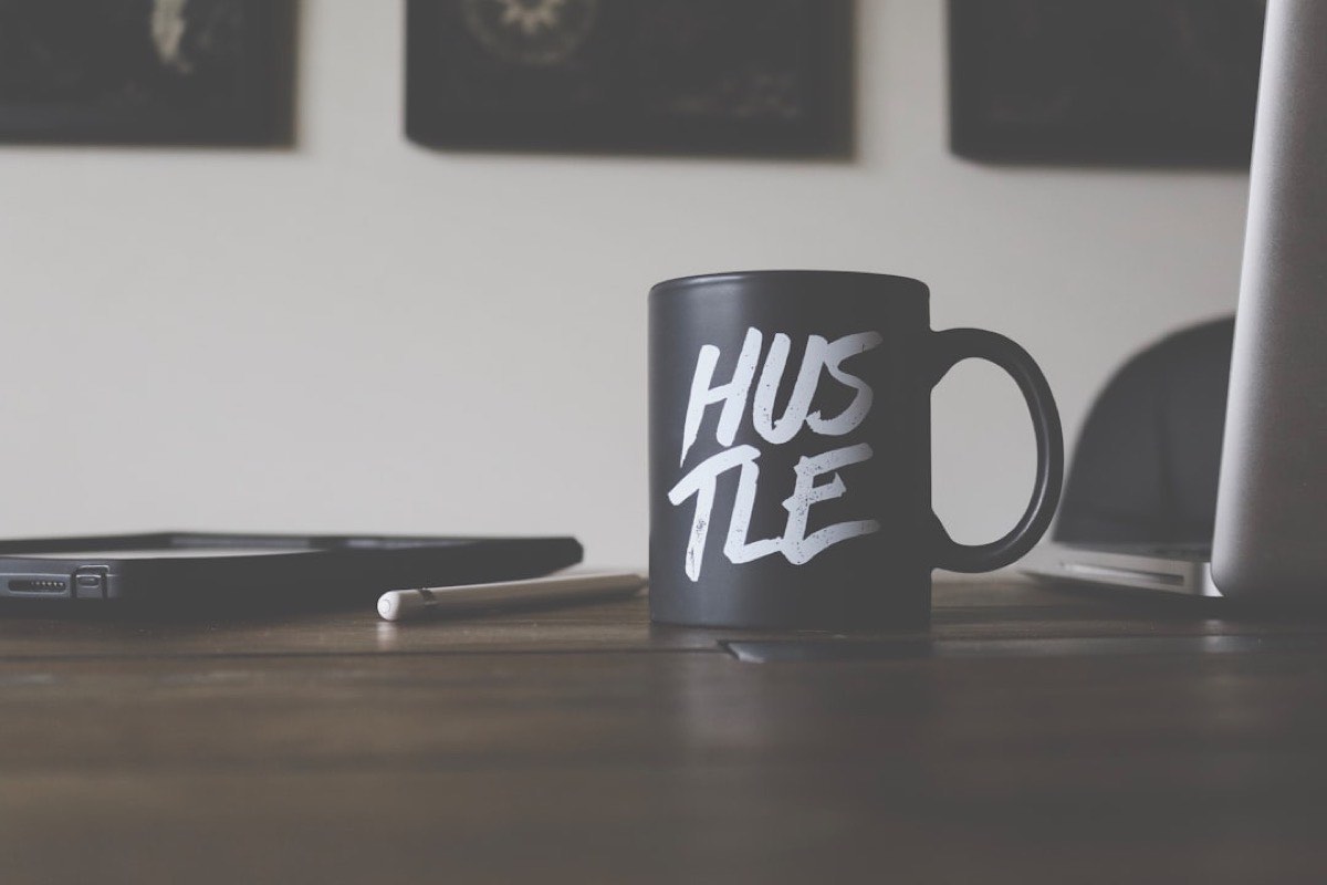 Mug Hustle sur le bureau d'un solopreneur qui se lance dans le solopreneuriat